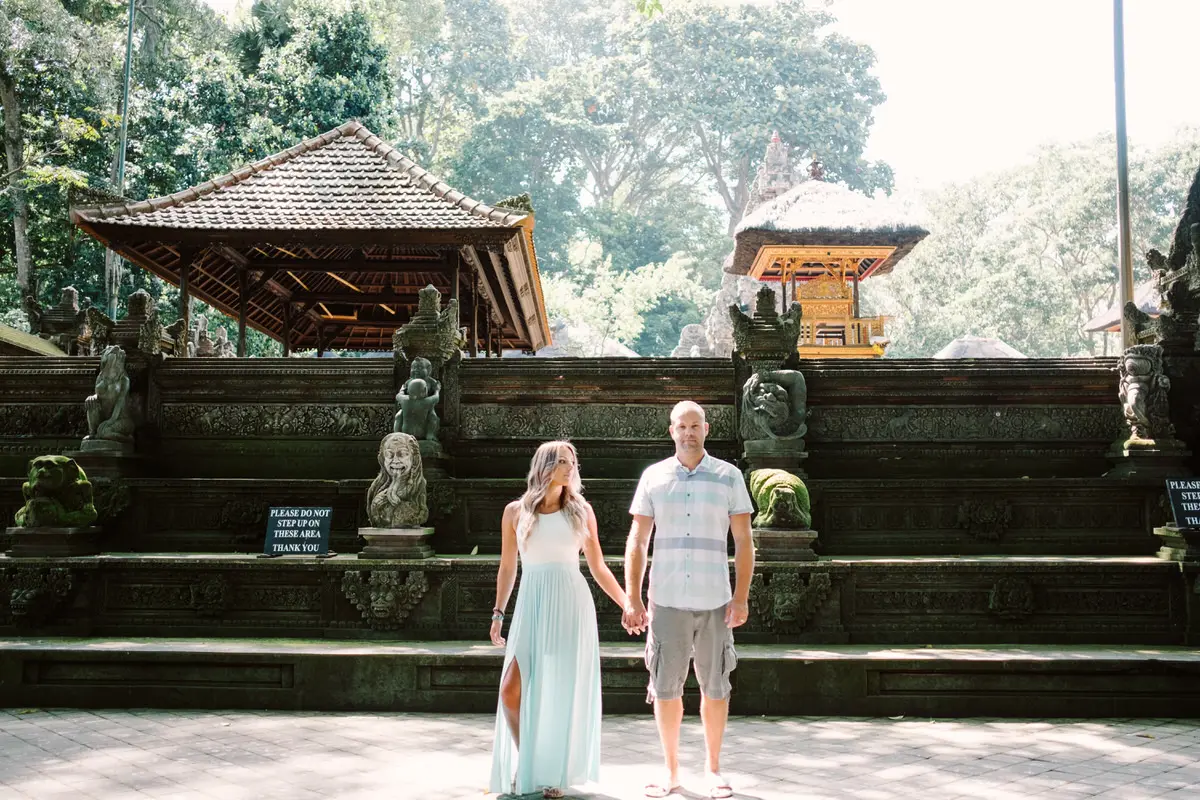 a couple pose in front of ubud monkey forest temple