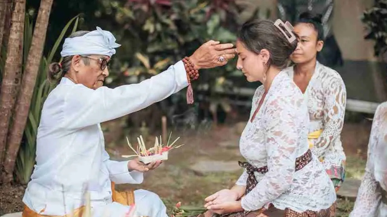 Balinese healer performing a traditional spiritual blessing
